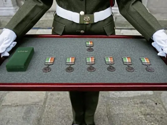 Military personnel holding a case of military medals
